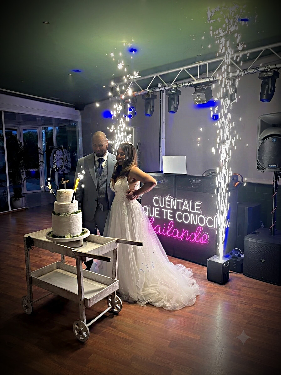 Los novios cortando la tarta entre chispas frías junto a la cabina de Sonoralia Experience